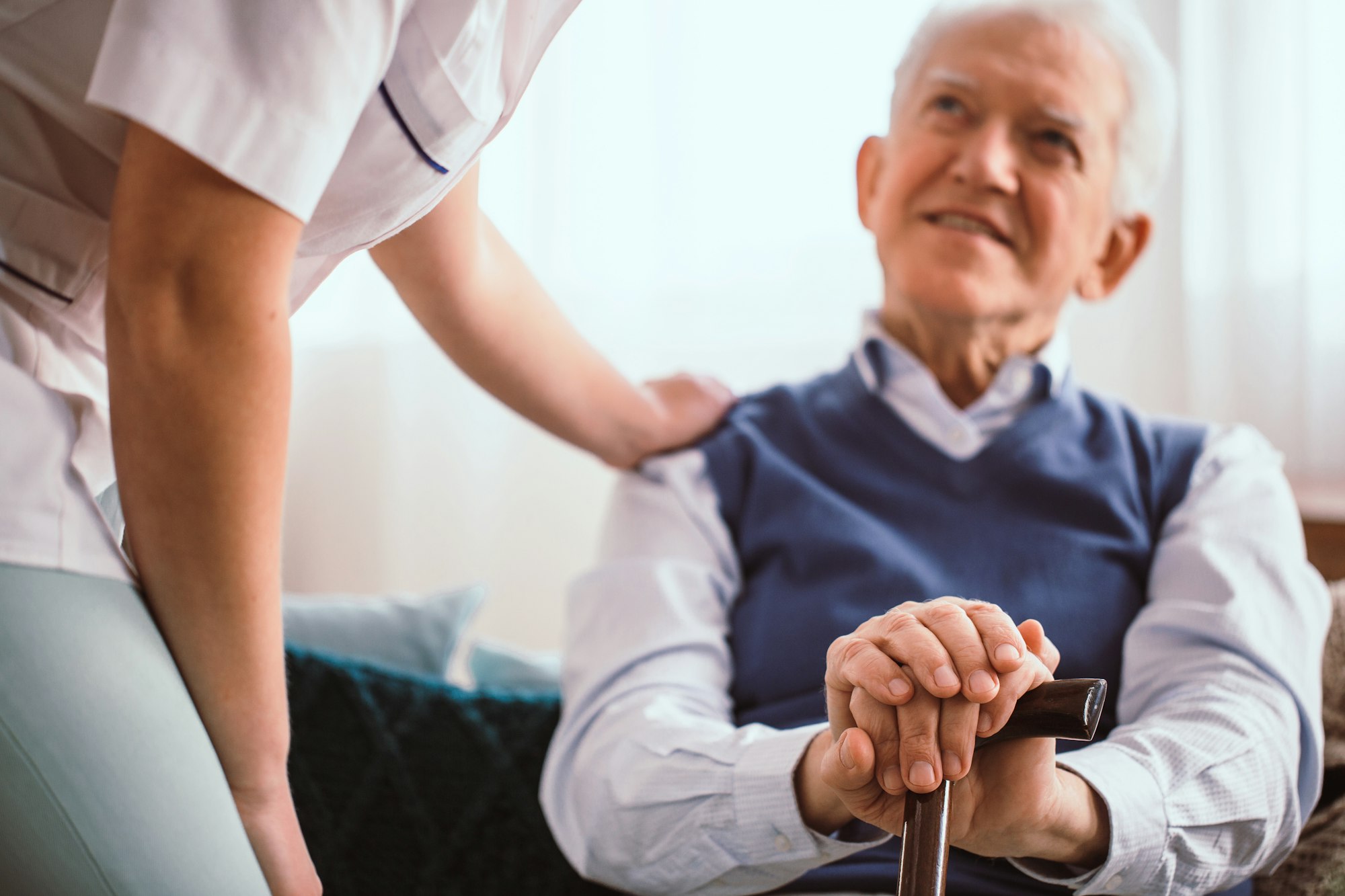Caregiver provides Best Home Care Services to an elderly man with a walking stick.